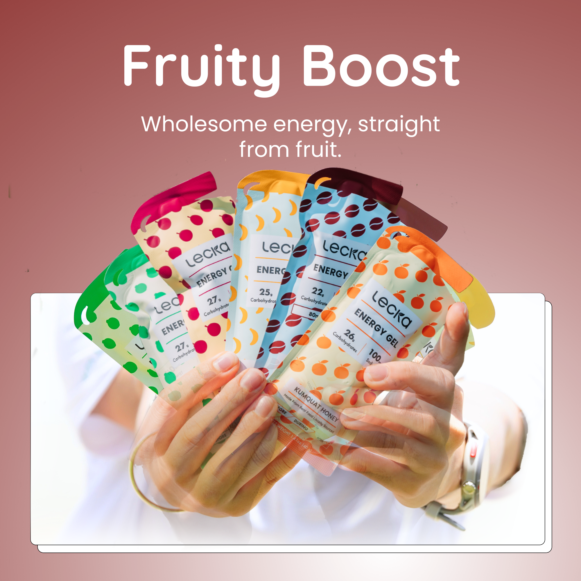 Hands holding Lecka energy gels with colorful packaging against a pink background, featuring the text 'Fruity Boost' and 'Wholesome energy, straight from fruit.'.
